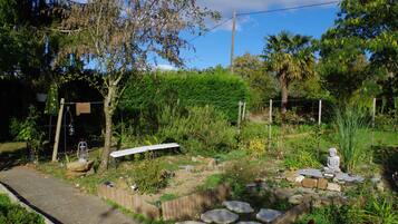 A garden with a Buddha statue, stone steps, and a wooden fence.