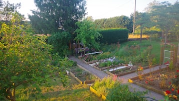 A garden with raised beds, a wooden structure, and a variety of plants.