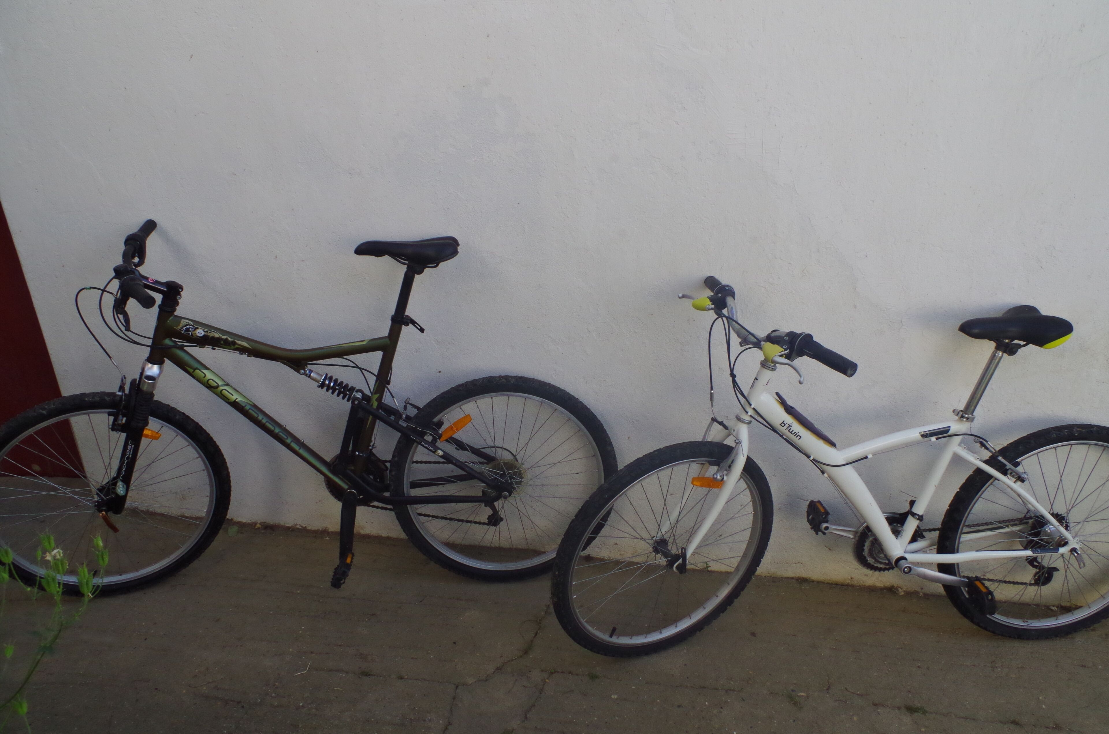 Dos bicicletas estacionadas junto a una pared.