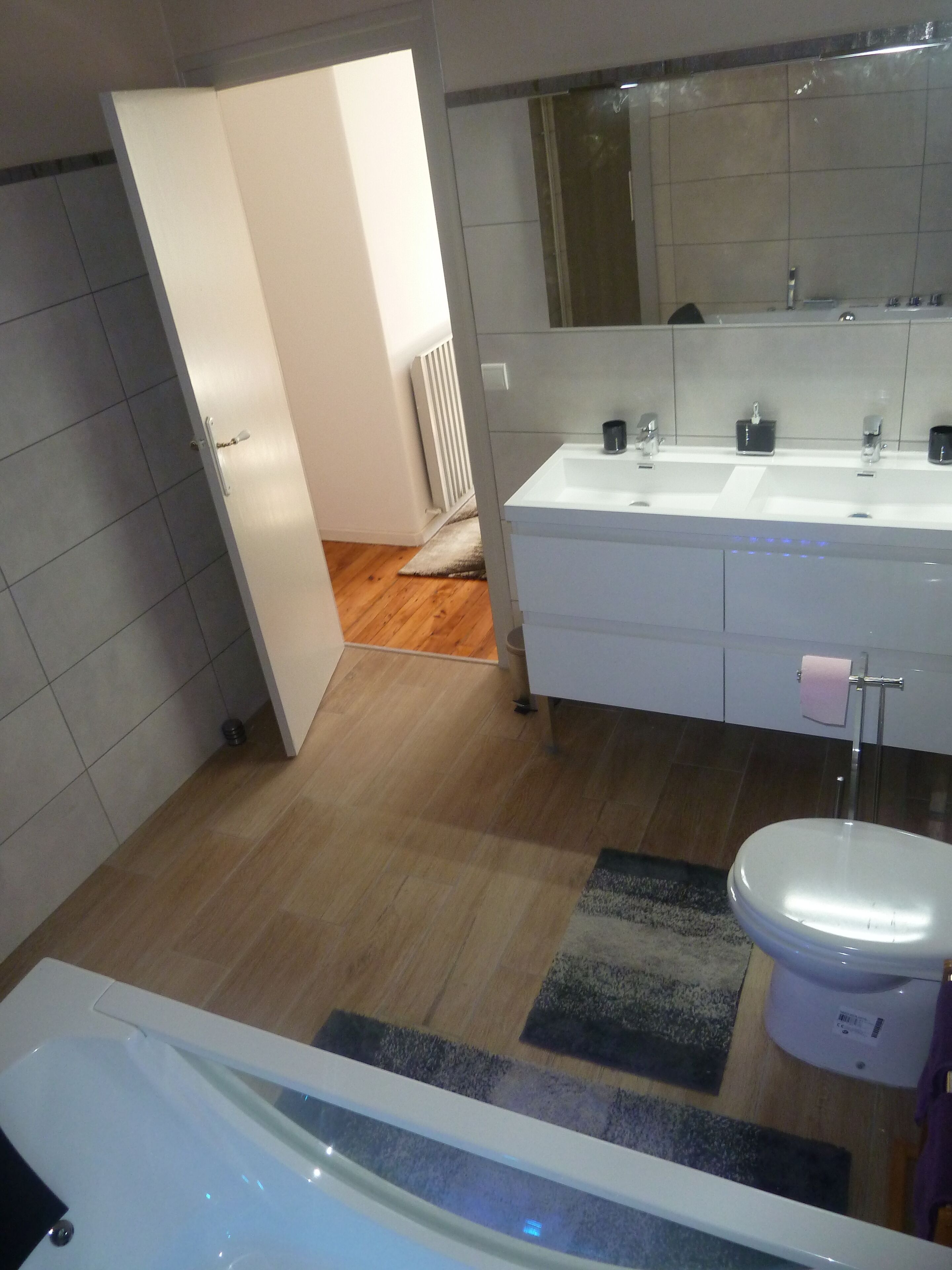 Bany modern amb un lavabo doble, vàter i banyera.