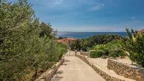 A pathway leading to a house with a view of the sea.