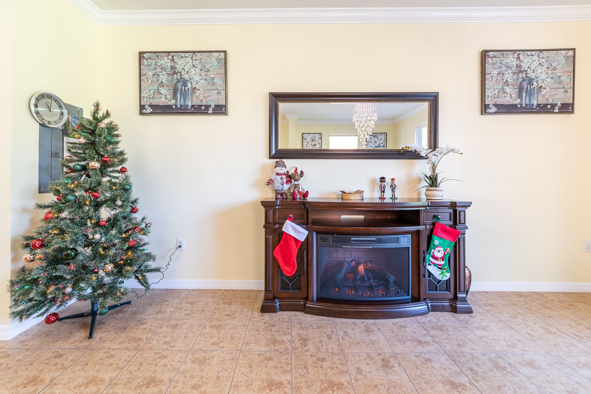 Una sala de estar con chimenea, un árbol de Navidad y decoración navideña.