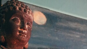 Une statue de Bouddha avec une bougie.