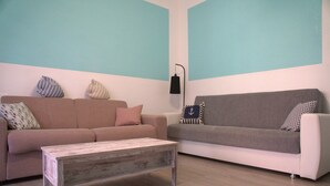 Un salon avec deux canapés, une table basse et un lampadaire.