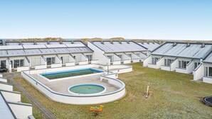 A modern residential complex with multiple two-story houses, a central swimming pool, and a small children's play area. - Feriehotel Tranum Klit (Brovst)