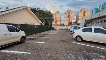 Un estacionamiento con varios coches blancos aparcados en plazas designadas.