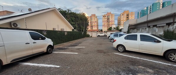 A parking lot with several white cars parked in designated spaces. - Hotel Hiperion (Maringá)