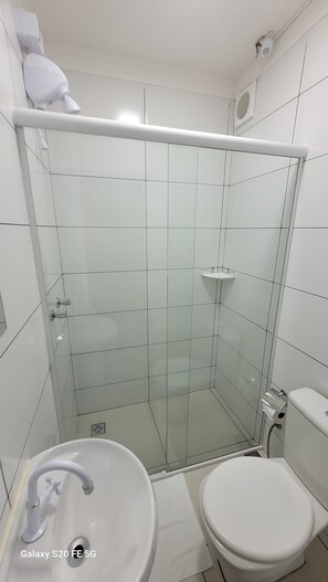 A modern bathroom with a glass shower enclosure, a white sink, and a toilet. - Hotel Hiperion (Maringá)