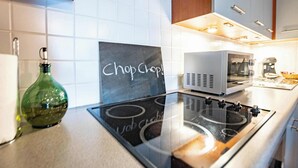 Een keuken met een gasfornuis, een magnetron en een schoolbord waarop “Chop Chop” staat.