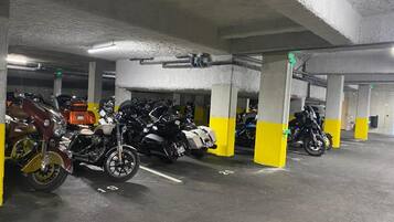 A multi-level parking garage with concrete pillars and yellow and white painted columns.