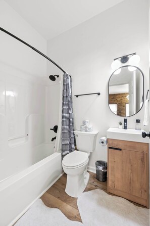 Bathtub, hair dryer, towels, shampoo