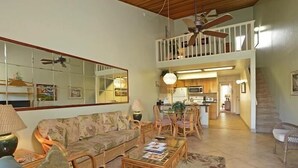 A spacious living room with a high ceiling, a dining area, and a kitchen in the background. - Hale Kamaole 262  Second floor large condo, Ocean view! (Kihei)