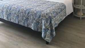 A bedroom with a large bed, two bedside tables with lamps, a ceiling fan, and a wall-mounted artwork. - Beach Paradise Found!  Direct oceanfront 9th floor updated and nicely decorated (Jensen Beach)