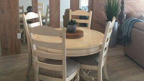 A dining area with a round wooden table and four chairs, a ceiling fan, and a potted plant. - Beach Paradise Found!  Direct oceanfront 9th floor updated and nicely decorated (Jensen Beach)