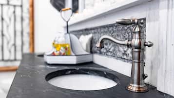 A bathroom with a black marble sink and a vintage-style faucet.