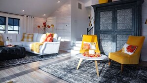 A modern living room with a white sofa, yellow armchairs, and a black ottoman. - Mabel and Harry's, a modern country guest house (Kokomo)