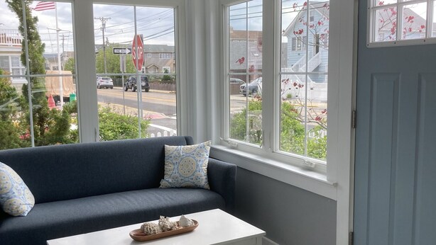 Ein Zimmer mit einem dunkelblauen Sofa, einem weißen Couchtisch und einem gemusterten Teppich.