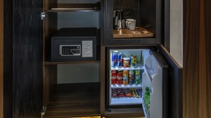 Ett kompakt kök med ett inbyggt kylskåp, en kaffebryggare och en mikrovågsugn.