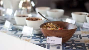 A breakfast buffet with various bowls of food, including a bowl labeled "MÜSLIK".