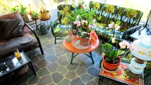 A cozy living room with a sofa, a coffee table with potted plants, and a patterned couch. - Melbourne-Indialantic-by-the-Sea, Florida (Indialantic)