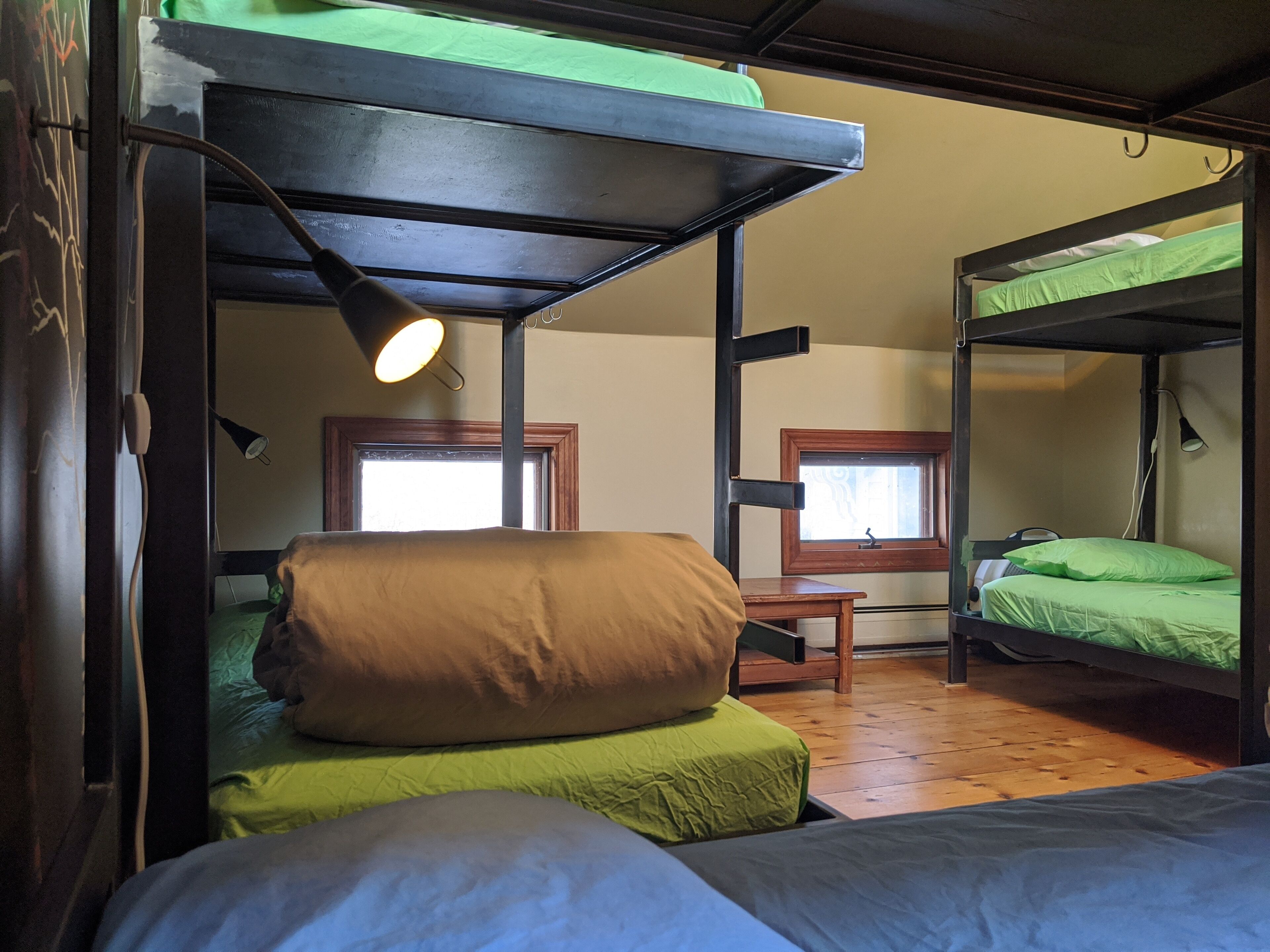 Une chambre de dortoir avec des lits superposés, un bureau et une fenêtre.