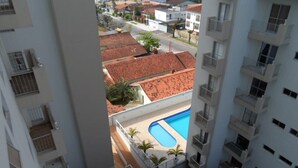 A view of a residential area with a swimming pool surrounded by buildings with red-tiled roofs. - Florida Beach Resort (Praia Grande) - Sea Front (praia grande)