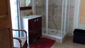 A bathroom with a glass shower enclosure, a sink, and a mirror. - House, large balcony with stairs down to the garden. (L'Argentière-la-Bessée)