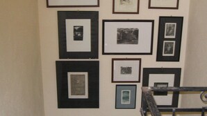 A wall with multiple framed black and white photographs arranged in a grid pattern. - Casa O is a 19th-century, restored, stone house with garden IT046022C2LZ5R4HQX (Pescaglia.)