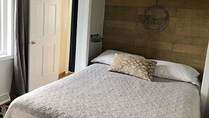 Ein Schlafzimmer mit Bett, Kopfteil, einer Willkommensanzeige und einer Tür.