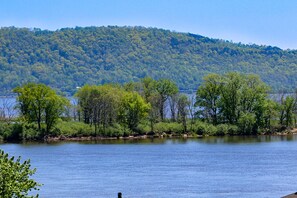 A calm lake with a forested hill in the background.