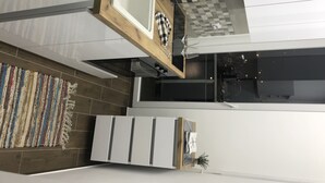 Eine moderne Küche mit Holzarbeitsplatte, karierter Spritzschutzwand und einer Pendelleuchte.