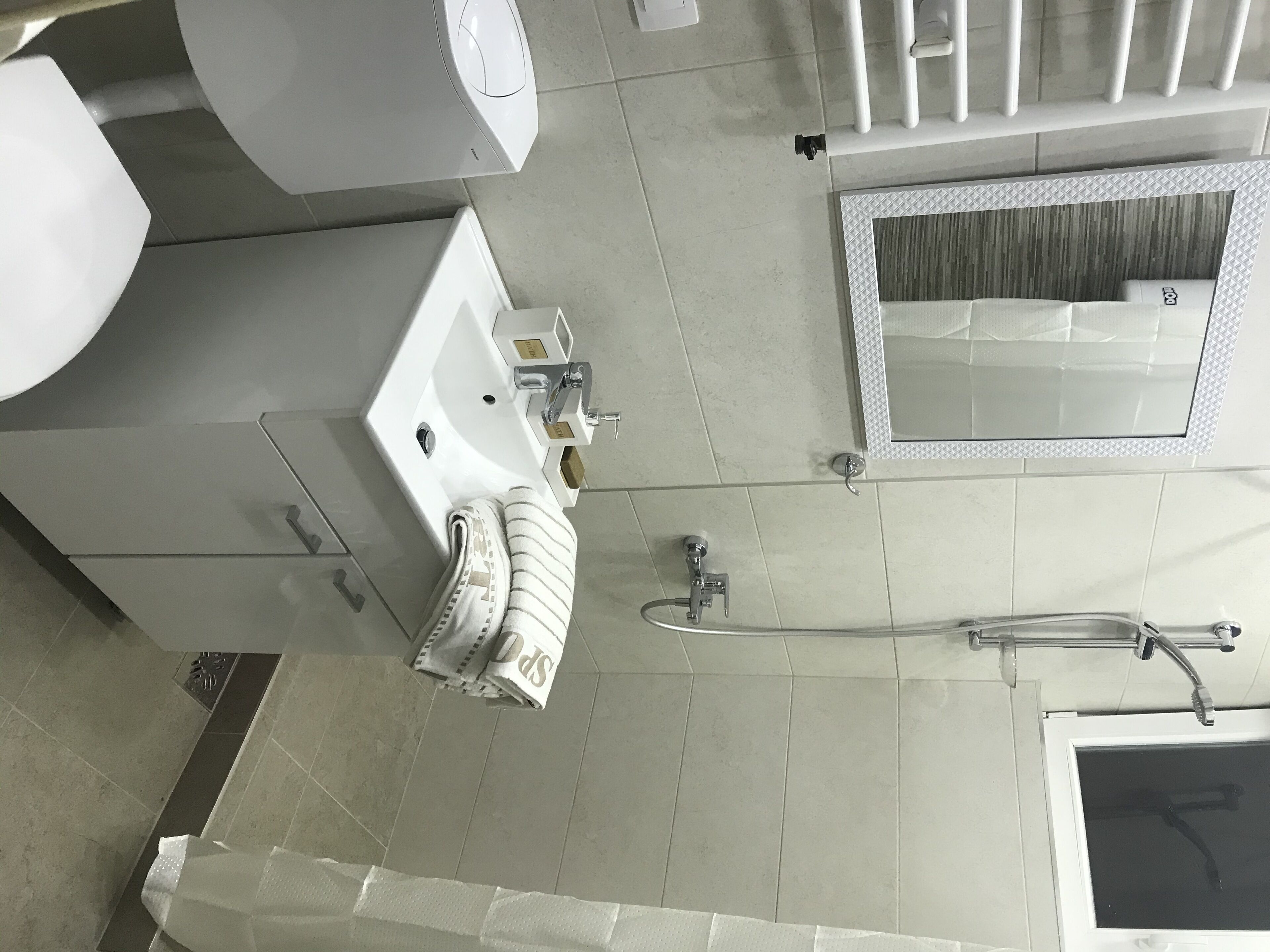 A modern bathroom with a sink, mirror, and shower.