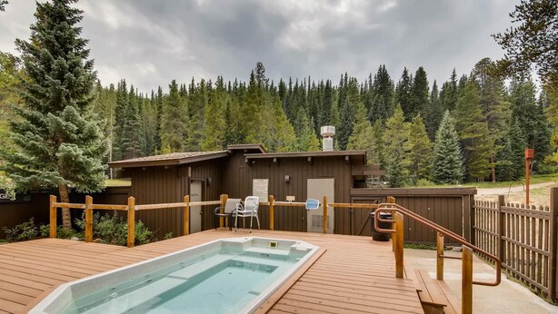 A hot tub on a wooden deck with a view of a forested area. - Perfect Ski In/Ski Out Condo in Center Village (Copper Mountain)