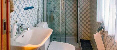 A bathroom with a sink, toilet, and shower.