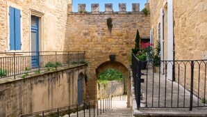 A stone staircase leading to an archway in a historic building with a metal railing and a view of the sky. - Homerez - Studio in Beaumont-du-Périgord (Beaumont-du-Périgord)