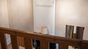 A staircase with a wooden railing, a white door with decorative moldings, and a light fixture above. - Homerez - Studio in Beaumont-du-Périgord (Beaumont-du-Périgord)