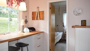 A compact kitchen with a window, a toaster, a sink, and a door leading to a bedroom. - 2 bedroom amazing home in Burseryd (Burseryd)