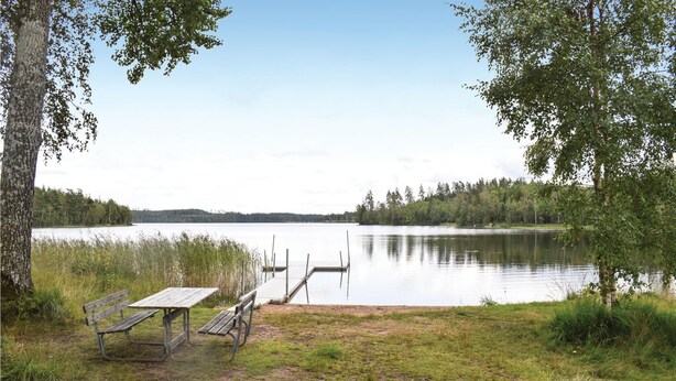 A lakeside view with a dock, a picnic table, and benches. - 2 bedroom amazing home in Burseryd (Burseryd)