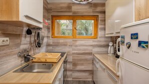 Eine moderne Küche mit Holzausstattung, einem integrierten Fenster und einem Edelstahl-Spülbecken.