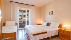 Une chambre d’hôtel avec deux lits, un balcon et une vue sur la ville.