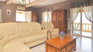 A living room with a beige sofa, a wooden coffee table, and a large wooden cabinet.