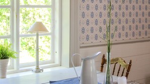 A room with a window, a table with a pitcher, a lamp, and a potted plant. - Amazing home in Gamleby (Gamleby)