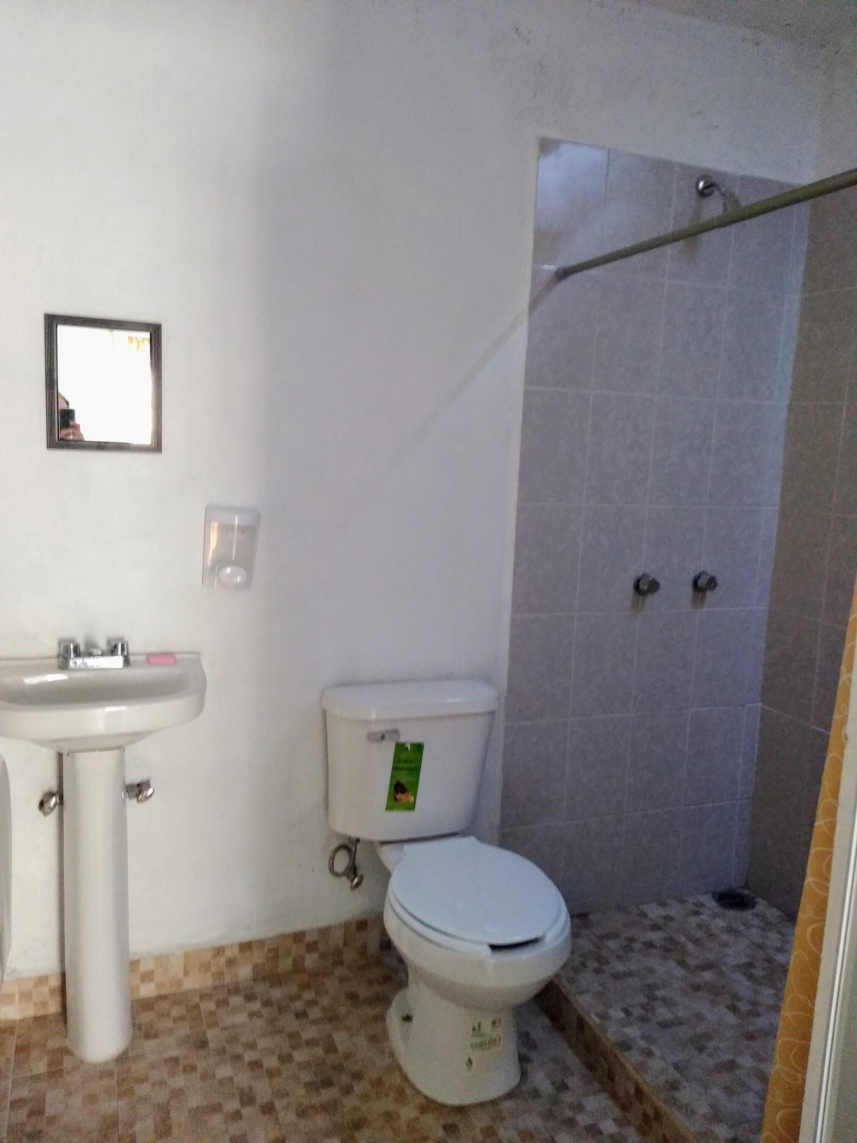 A bathroom with a sink, toilet, and shower area.