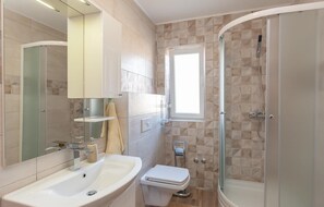 A modern bathroom with a sink, toilet, and shower. - Amazing home in Lokvicici (Lokvicici)