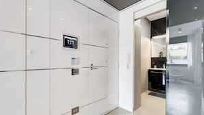 A modern hotel room with a large wardrobe, a control panel, and a view of the outside.