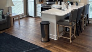 A modern kitchen with white cabinets, a stainless steel refrigerator, a microwave, and a large island with bar stools. - Beautiful ocean views all rooms. Very close to beach. Four bedrooms, 3.5 baths. (St. Helena Island)