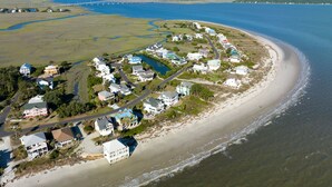 An aerial view of a coastal residential area with houses along the beach, a bridge in the background, and a river running through the landscape. - Beautiful ocean views all rooms. Very close to beach. Four bedrooms, 3.5 baths. (St. Helena Island)