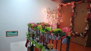 Una escalera adornada con decoraciones plásticas de colores y un letrero que indica una salida de emergencia.