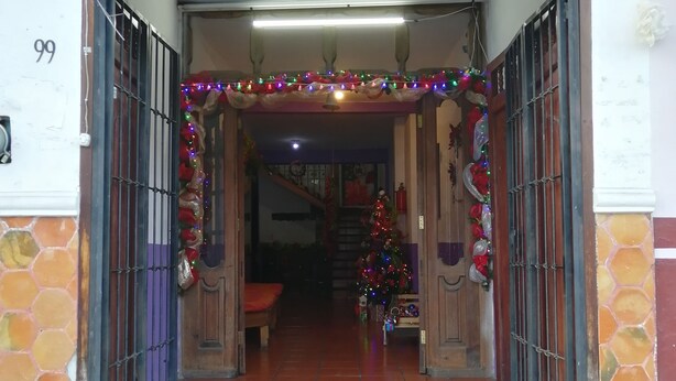 La entrada de un hotel llamado "Hotel Puente Blanco" con un letrero que enumera servicios como baños limpios, tarifas económicas, agua caliente, catering e internet.
