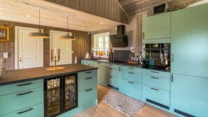 A modern kitchen with teal cabinets, a black countertop, and a wooden ceiling. - Lovely home in Rendalen with WiFi (Rendalen)